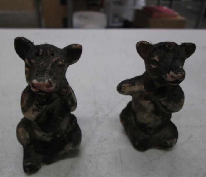 Cow salt and pepper shakers covered in soot