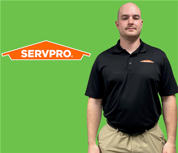 Zach, Project Manager, in front of SERVPRO green and logo