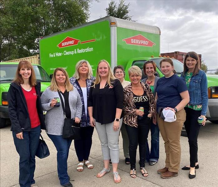 a group of women standing in front of a truck